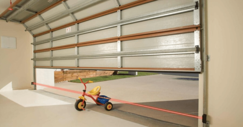 Garage door with safety beam and tricycle.