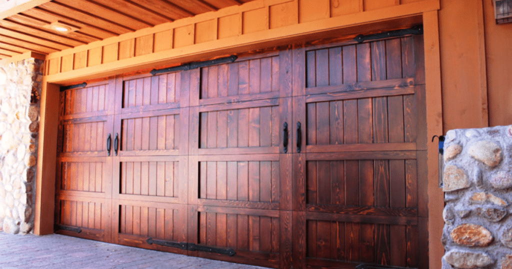 Wooden garage doors with rustic design and iron hardware.